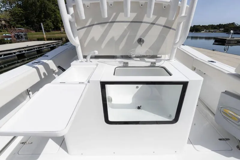 Slide: The Image of 2024 Sea Hunt Gamefish 28 boat interior with white seating on calm water. - 7