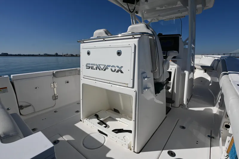 Slide: The Image of 2020 Sea Fox 288 Commander boat interior with seating and storage, on calm water. - 13