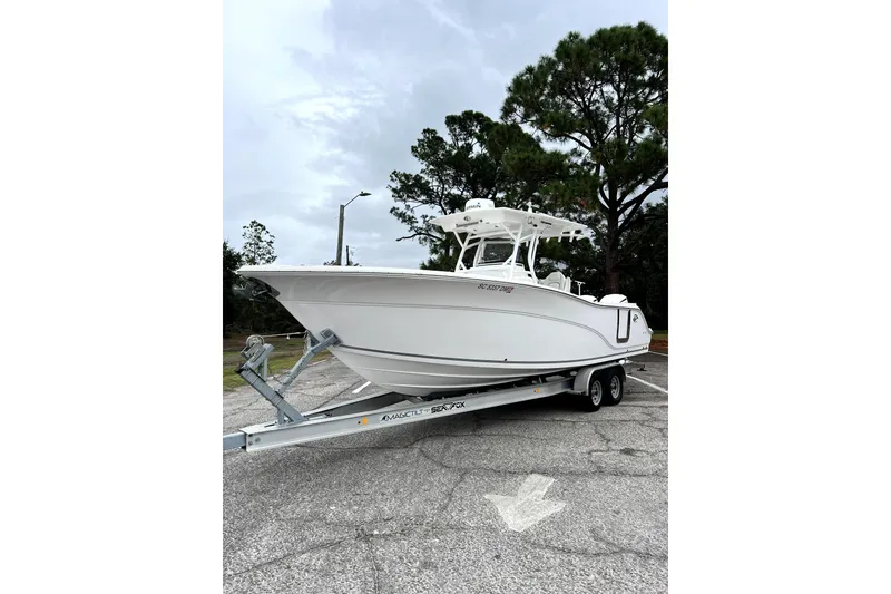 Slide: The Image of 2020 Sea Fox 288 Commander boat on water with bridge in background. - 2
