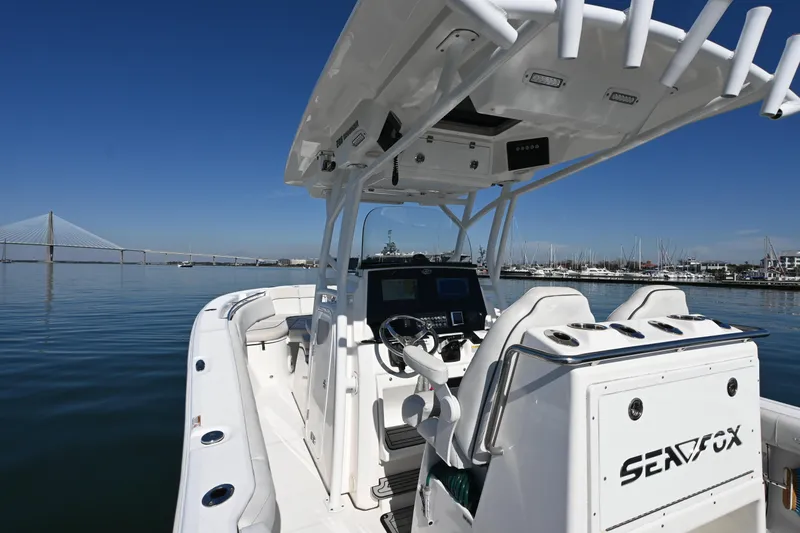 Slide: The Image of 2020 Sea Fox 288 Commander boat on calm water with bridge and marina background. - 7