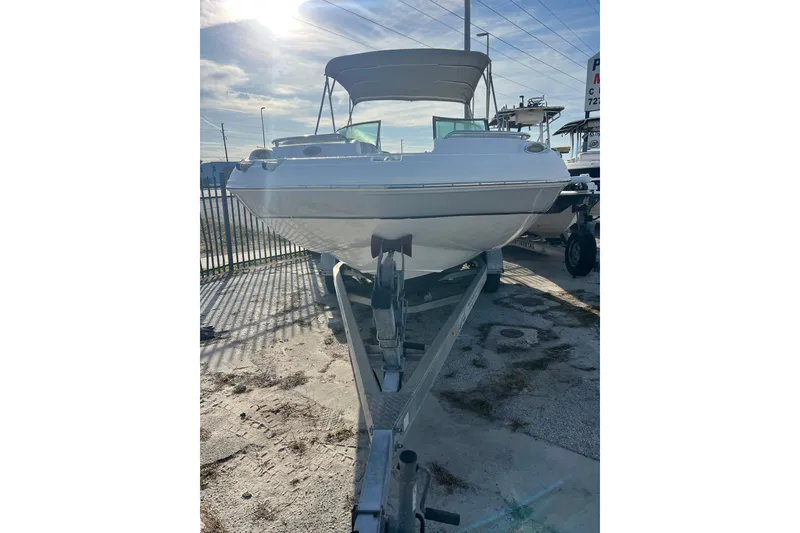 Slide: The Image of 2017 Hurricane SunDeck 2200 DC OB boat on trailer, parked outdoors under sunny sky. - 3
