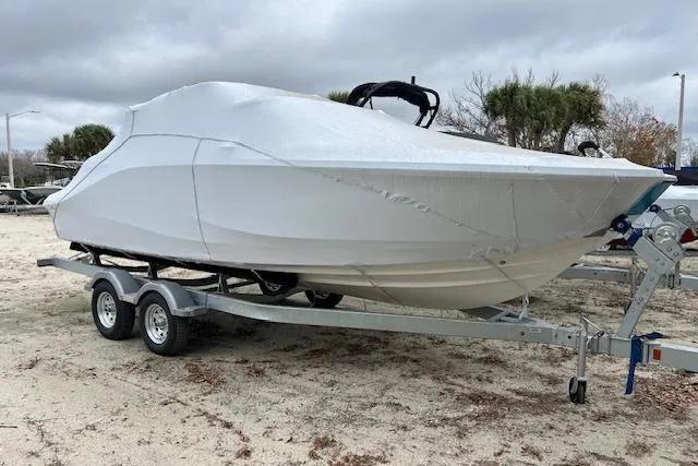 The Image of Covered 2026 Bayliner V20 boat on trailer, parked outdoors under cloudy skies. - 1