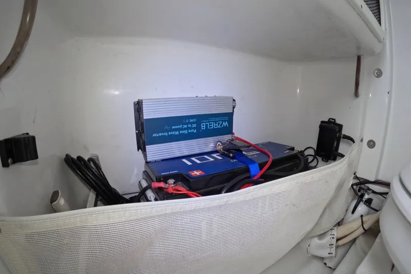 Slide: The Image of 2019 Sea Hunt Gamefish 25 battery compartment with inverter and wiring. - 11