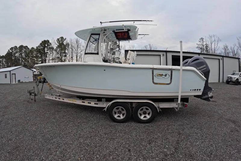 Slide: The Image of 2019 Sea Hunt Gamefish 25 boat on trailer, parked outdoors near storage buildings. - 15