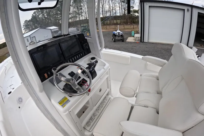 Slide: The Image of 2019 Sea Hunt Gamefish 25 boat interior with steering console and dual screens. - 2