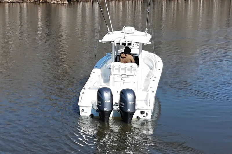 Slide: The Image of 2019 Sea Hunt Gamefish 25 boat with dual Yamaha engines on calm water. - 22