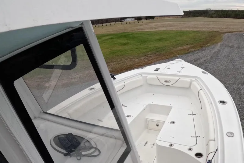 Slide: The Image of 2019 Sea Hunt Gamefish 25 boat, white interior, parked on gravel near grassy field. - 6