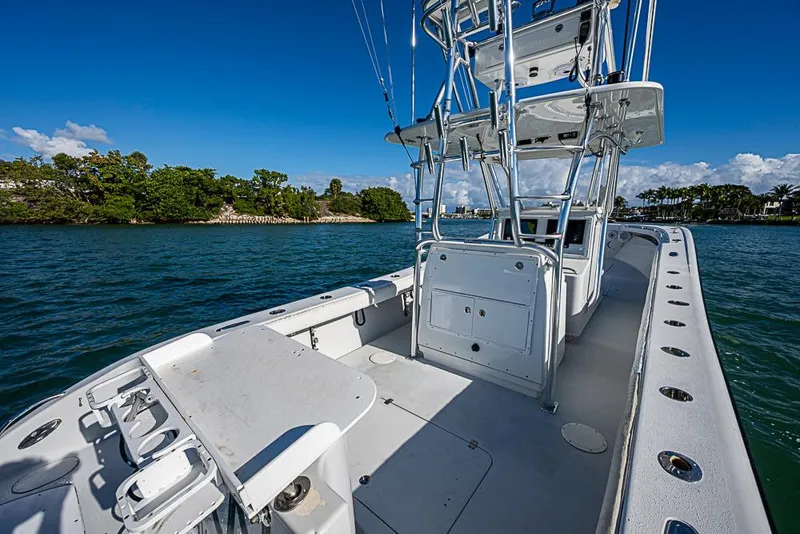 Slide: The Image of 2002 Yellowfin 36 Offshore boat on water, clear sky, lush shoreline in background. - 12