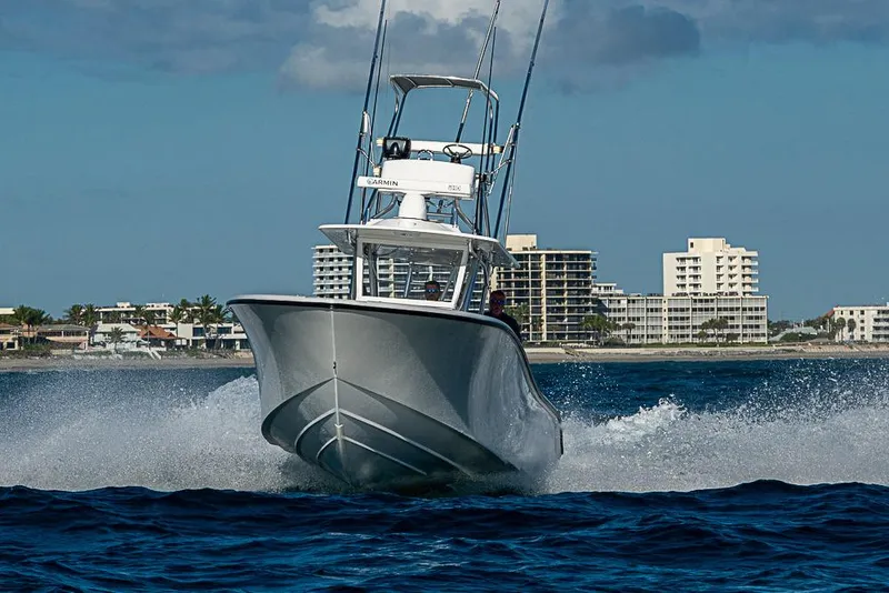Slide: The Image of 2002 Yellowfin 36 Offshore boat cruising on ocean near coastal buildings. - 30