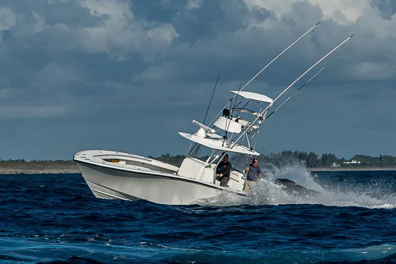 Slide: The Image of 2002 Yellowfin 36 Offshore boat navigating rough seas under cloudy skies. - 31
