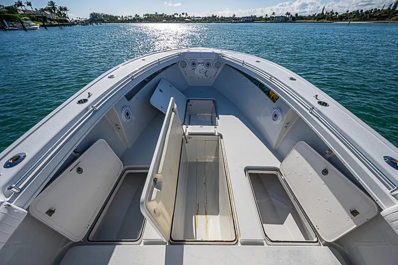 Slide: The Image of 2002 Yellowfin 36 Offshore boat deck with open storage compartments on calm water. - 6