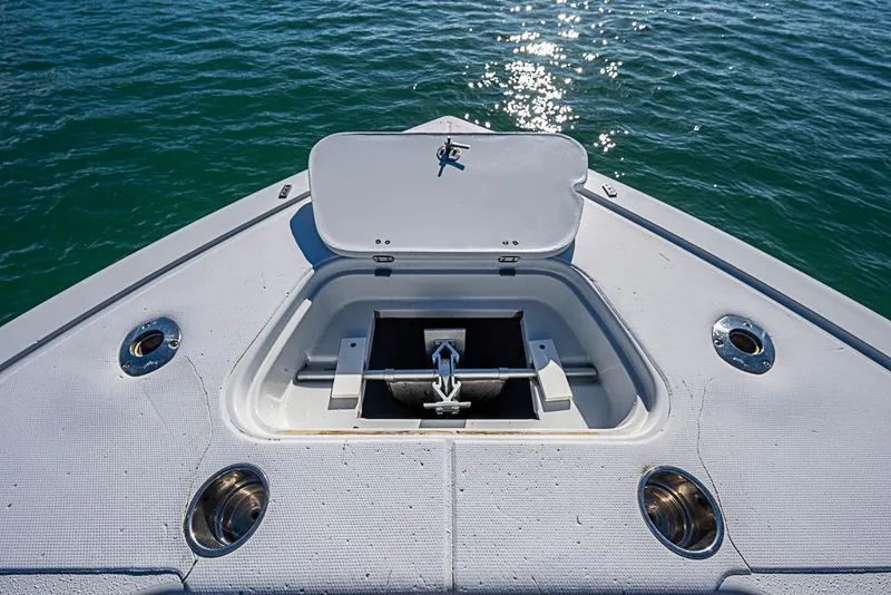 Slide: The Image of Bow of 2002 Yellowfin 36 Offshore boat with anchor compartment open on calm water. - 9