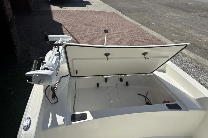 Slide: The Image of 2026 Mako Pro Skiff 15 CC boat with open storage compartment and trolling motor. - 11