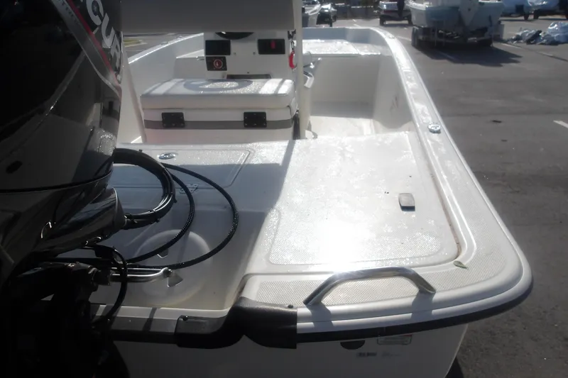 Slide: The Image of 2026 Mako Pro Skiff 17 CC boat with outboard motor in a parking lot. - 13