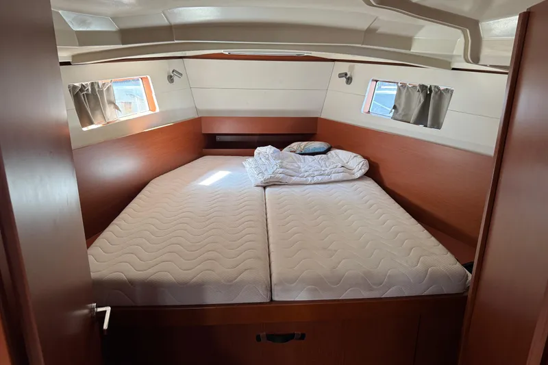 Slide: The Image of 2019 Beneteau Oceanis 41.1 cabin interior with double bed and porthole windows. - 10