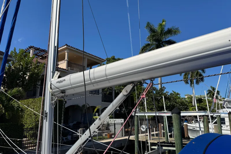 Slide: The Image of 2019 Beneteau Oceanis 41.1 sailboat mast and boom, docked near tropical waterfront homes. - 14