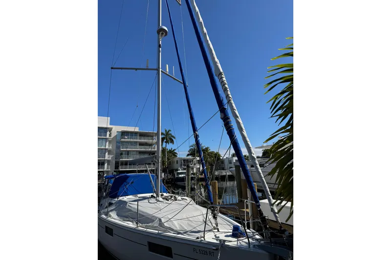 Slide: The Image of 2019 Beneteau Oceanis 41.1 sailboat docked, with clear blue sky and palm trees. - 15