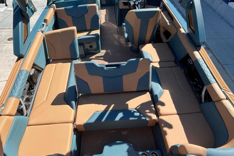 Slide: The Image of 2026 MasterCraft XT24 boat interior with tan and blue seating, showcasing spacious and luxurious design. - 9