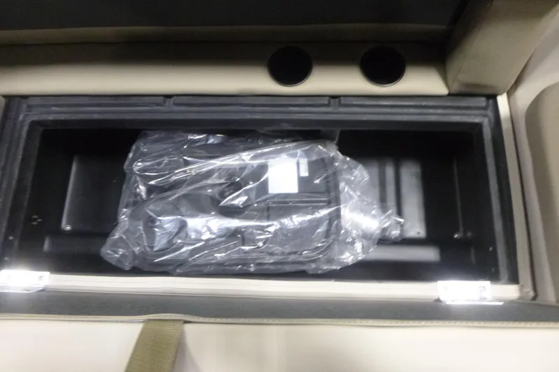 Slide: The Image of Storage compartment in 2026 Premier 220 Sunscape RF boat, featuring a plastic-wrapped item. - 9