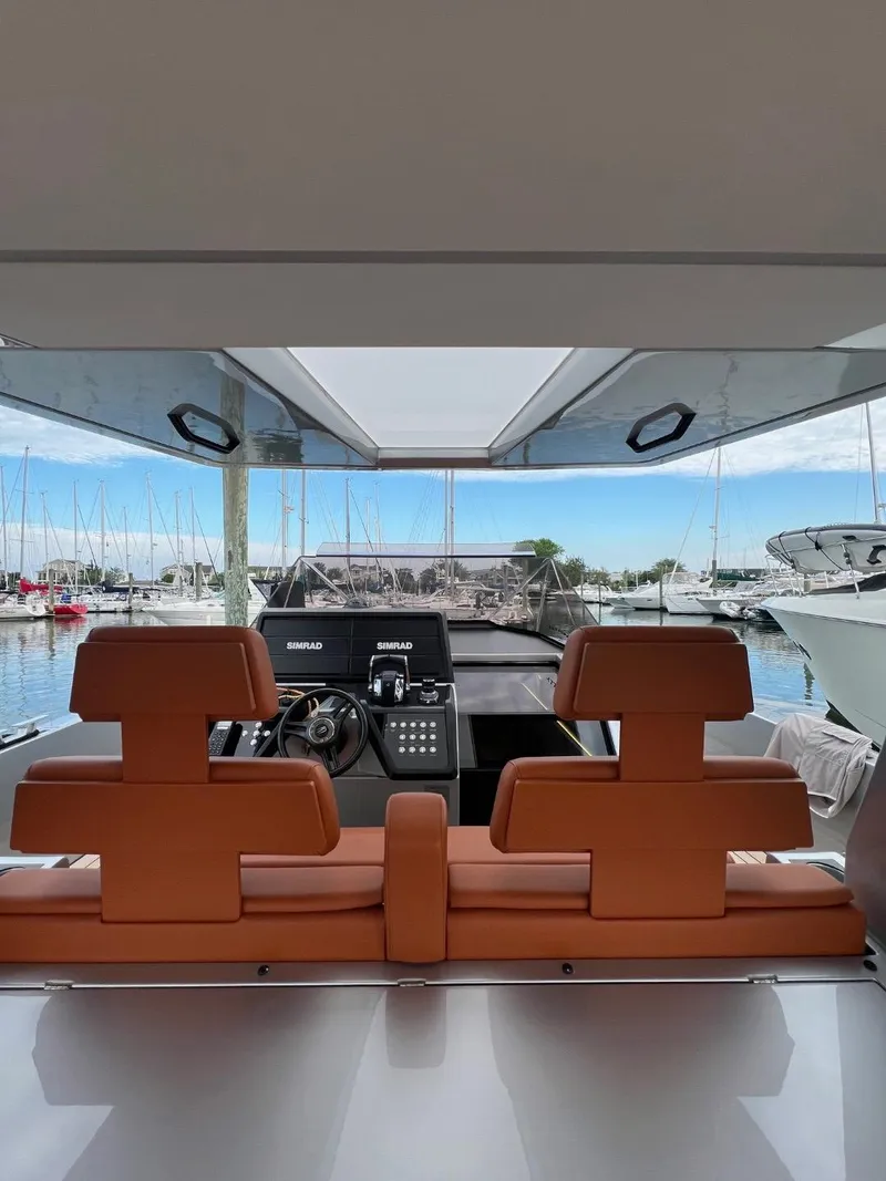 Slide: The Image of Interior view of 2023 Wally 48 X yacht with leather seating and marina backdrop. - 23