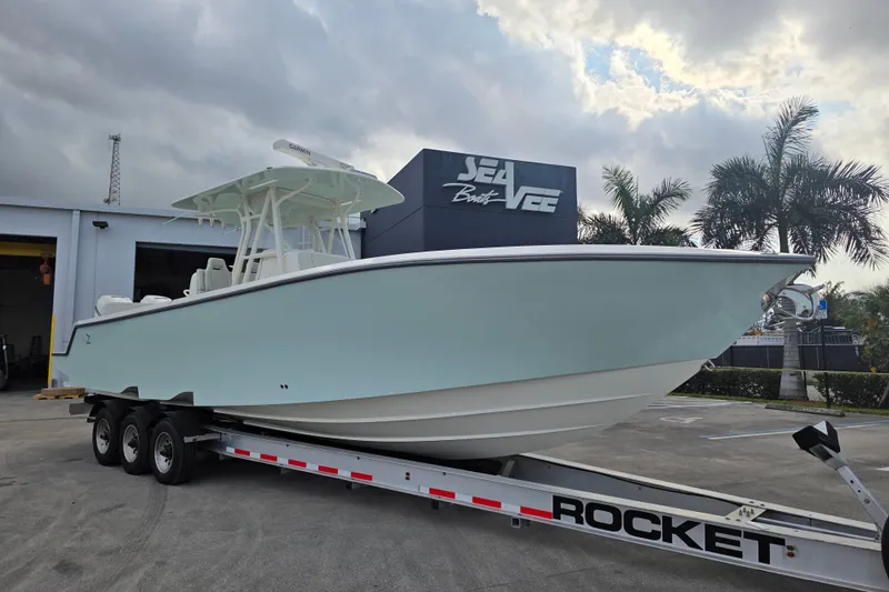 The Image of 2022 SeaVee 340Z boat on trailer at dealership, cloudy sky background. - 1