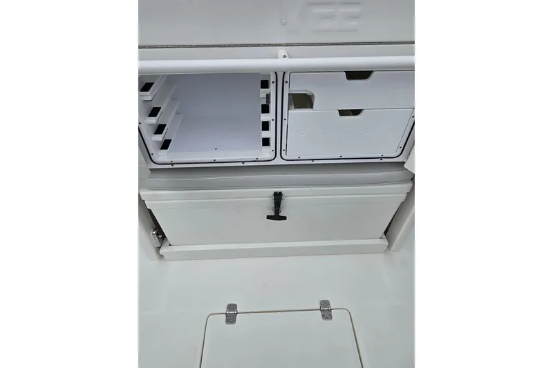 Slide: The Image of 2022 SeaVee 340Z boat storage compartments with white drawers and latch. - 18