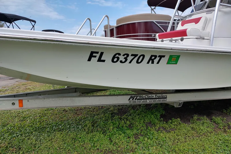 Slide: The Image of 2016 Fat Cat 21 boat on trailer, registration FL 6370 RT, parked on grass. - 11