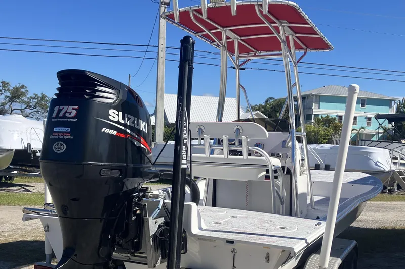 Slide: The Image of 2016 Fat Cat 21 boat with Suzuki 175 outboard motor and red canopy, parked outdoors. - 14