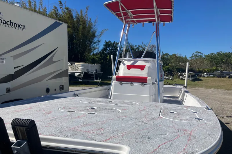 Slide: The Image of 2016 Fat Cat 21 boat with Suzuki 175 outboard motor and red canopy, parked outdoors. - 2