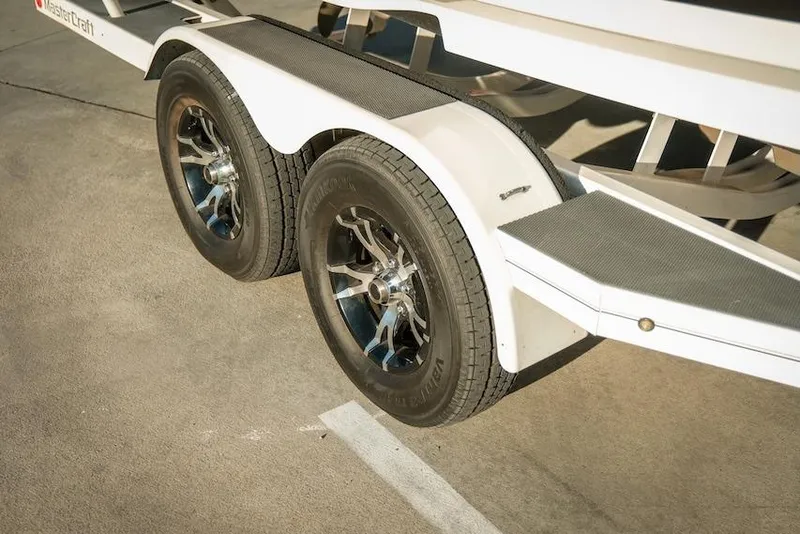 Slide: The Image of Trailer wheels of a 2013 MasterCraft X-2 boat on a concrete surface. - 19