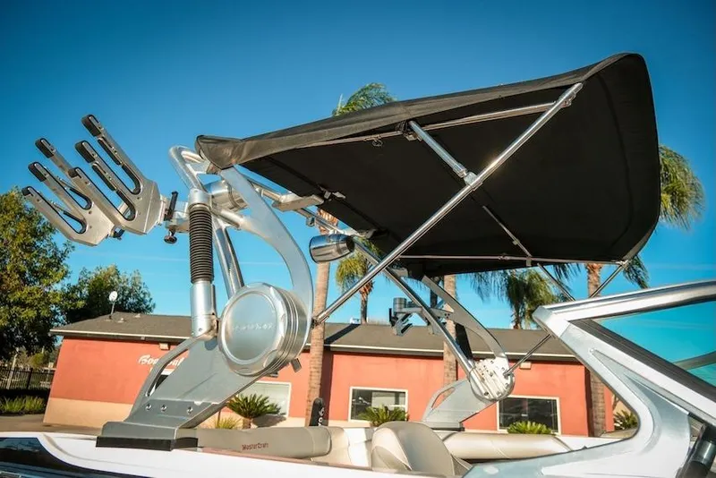 Slide: The Image of 2013 MasterCraft X-2 boat with wakeboard tower and bimini top against blue sky. - 20