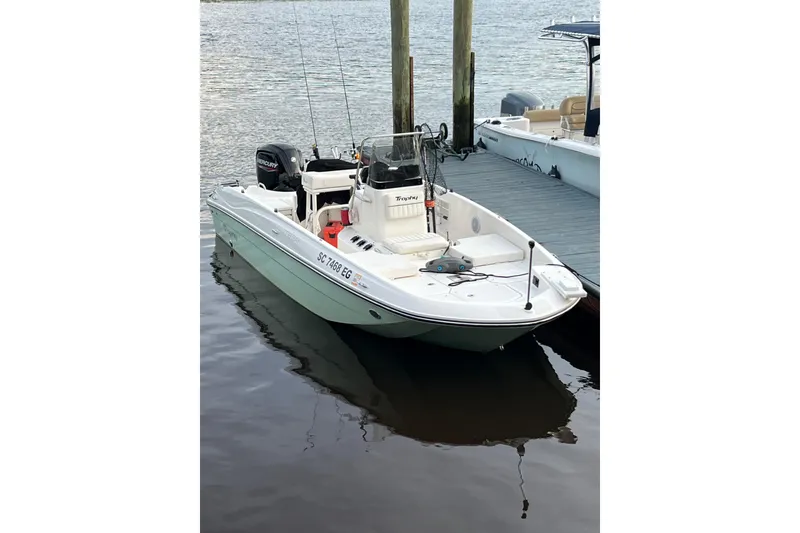 Slide: The Image of 2023 Trophy T-18 boat docked on calm water, featuring a sleek design and modern equipment. - 18