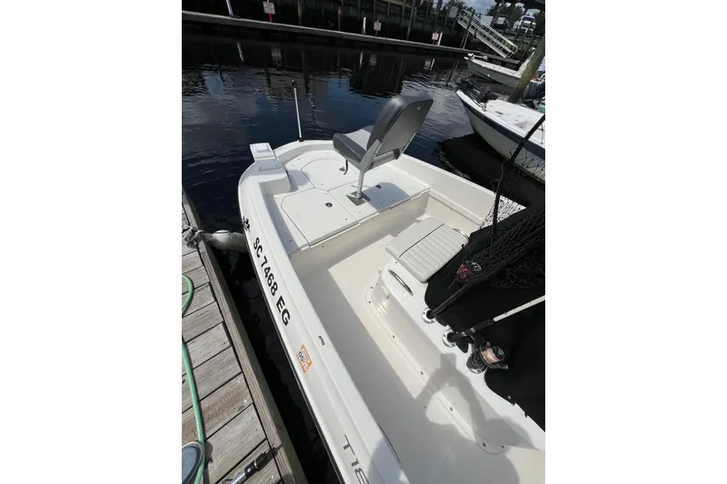 Slide: The Image of 2023 Trophy T-18 boat docked, featuring seating and fishing gear. - 22