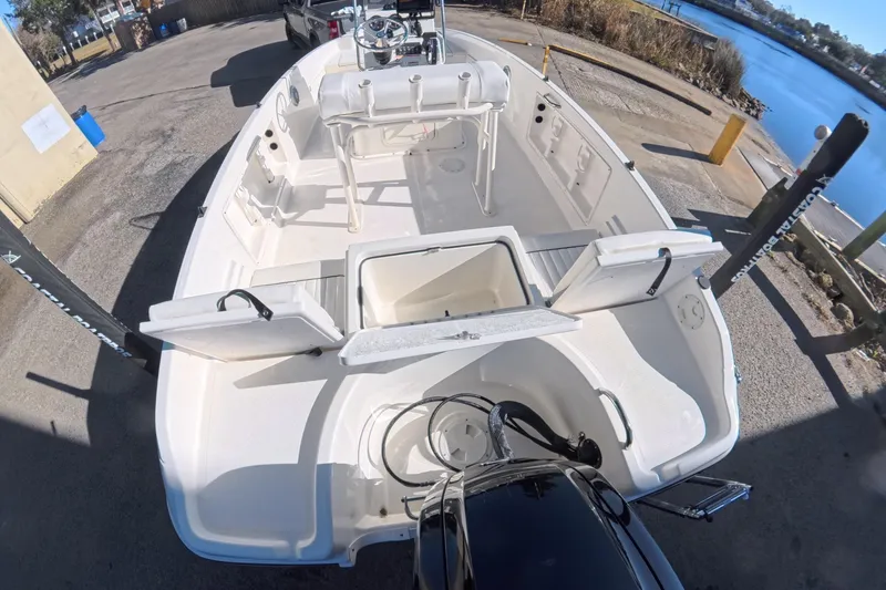 Slide: The Image of 2023 Trophy T-18 boat with open storage compartments, docked by a serene waterfront. - 7