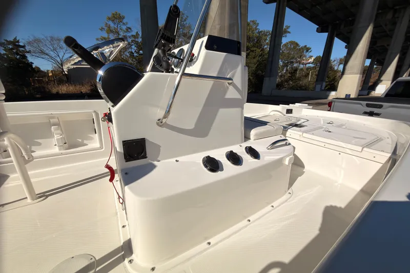 Slide: The Image of 2023 Trophy T-18 boat interior with steering console and seating under a bridge. - 8