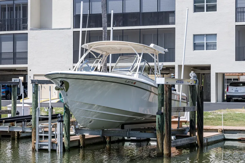 The Image of 2017 Grady-White Freedom 285 boat docked on a lift near waterfront apartments. - 0
