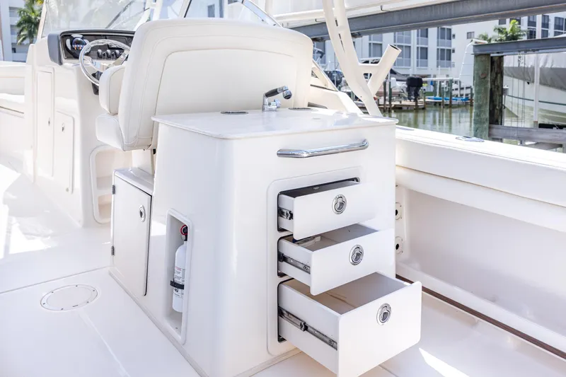 Slide: The Image of 2017 Grady-White Freedom 285 boat interior with open storage drawers and helm station. - 21