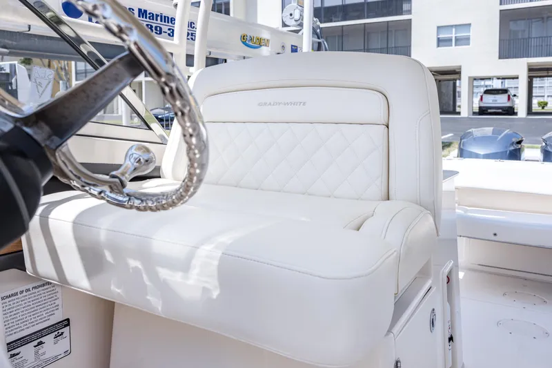 Slide: The Image of 2017 Grady-White Freedom 285 boat interior with white leather seating and steering wheel. - 32