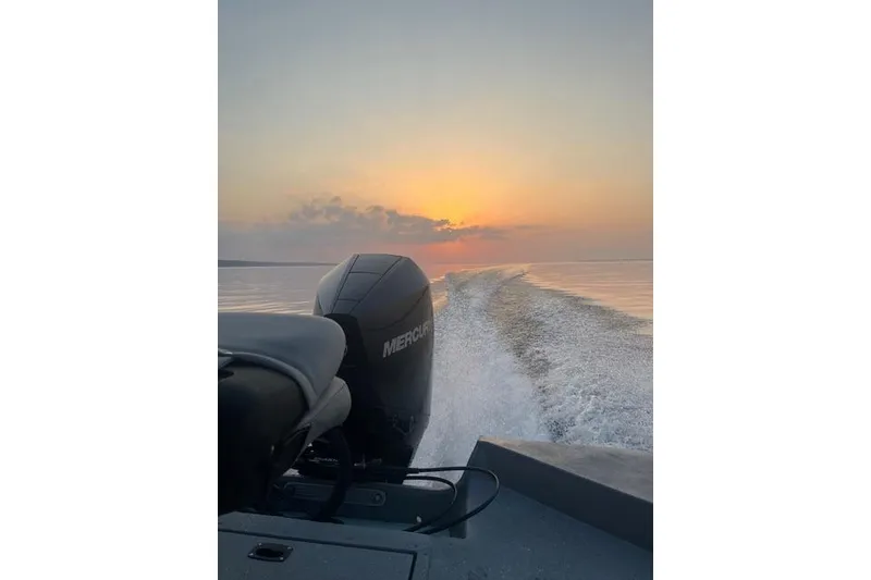 Slide: The Image of 2023 SeaArk Big Easy boat cruising at sunset with Mercury engine. - 12