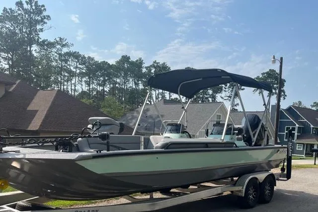 Slide: The Image of 2023 SeaArk Big Easy boat on trailer, parked in residential area with trees. - 8