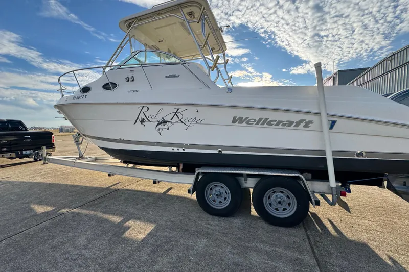 Slide: The Image of 2009 Wellcraft 270 Coastal O/B boat on trailer under a partly cloudy sky. - 15
