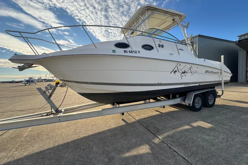 Slide: The Image of 2009 Wellcraft 270 Coastal O/B boat on trailer under a partly cloudy sky. - 17