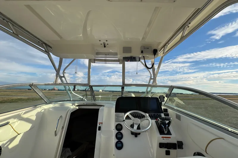 Slide: The Image of 2009 Wellcraft 270 Coastal O/B boat interior with steering console and open water view. - 19