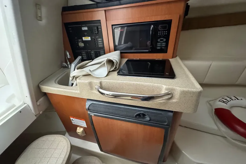 Slide: The Image of 2009 Wellcraft 270 Coastal O/B cabin interior with kitchenette, microwave, and control panel. - 27