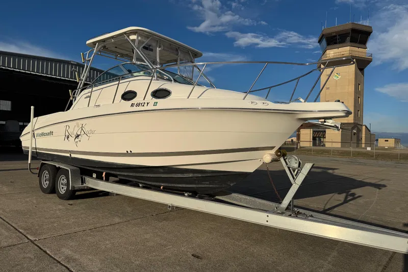 Slide: The Image of 2009 Wellcraft 270 Coastal O/B boat on trailer near an airport control tower. - 3