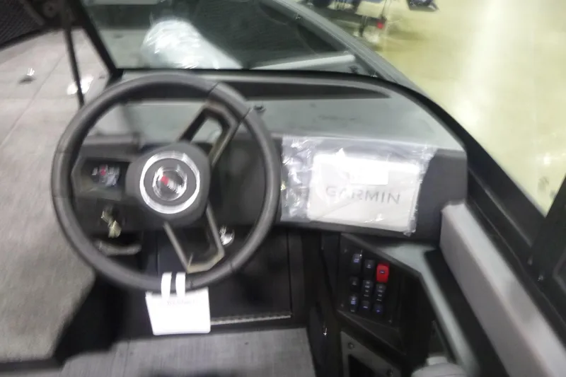 Slide: The Image of 2026 Alumacraft Trophy 205X Sport boat dashboard with steering wheel and Garmin display. - 11