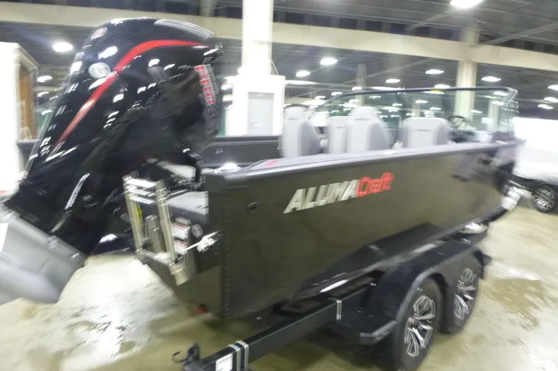 Slide: The Image of 2026 Alumacraft Trophy 205X Sport boat with powerful outboard motor in showroom. - 2