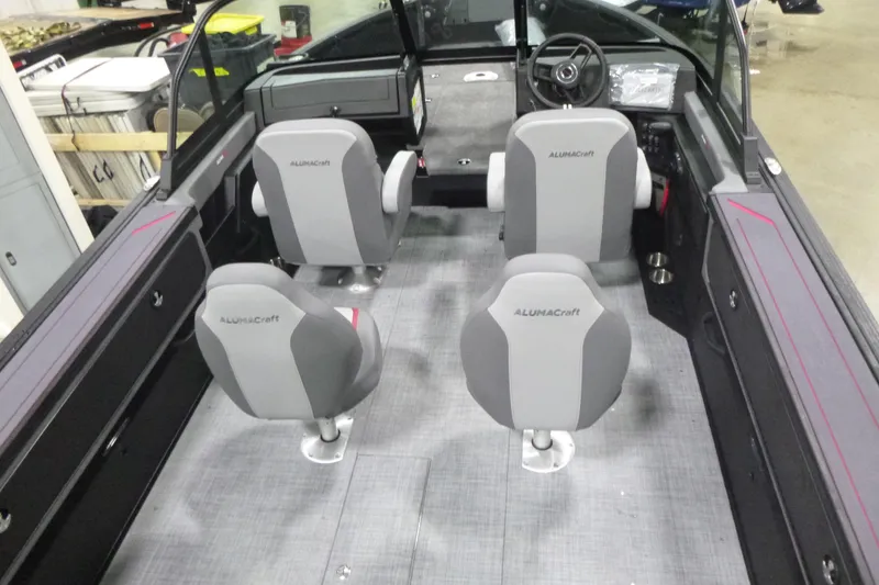 Slide: The Image of 2026 Alumacraft Trophy 205X Sport boat interior with four gray seats and steering console. - 3