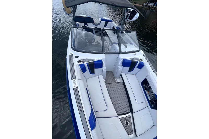 Slide: The Image of 2017 Nautique Super Air Nautique G25 boat interior with blue and white seating on water. - 16