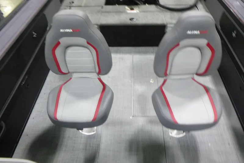 Slide: The Image of 2025 Alumacraft Trophy 205X Sport boat interior with two gray and red seats. - 11